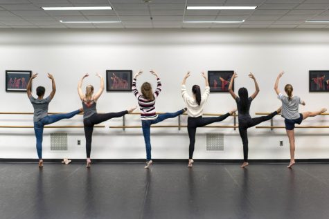 Dancers stretch at the barre before rehearsing.