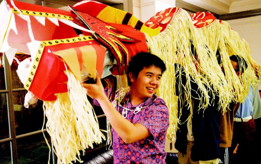 YY Cher ’20 helps hold a red dragon decoration during the Lunar New Year celebration in the Student Center on Monday, February 4.