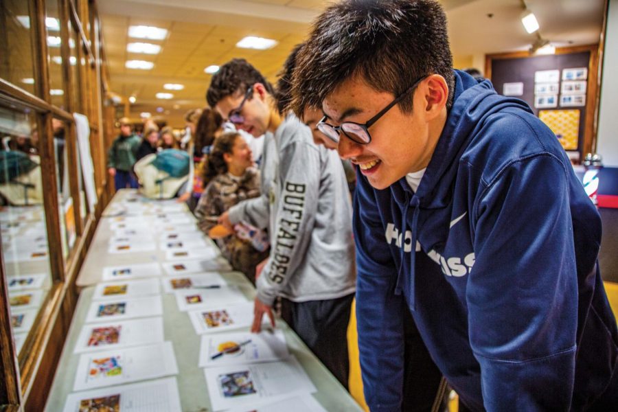 Ryan Tse ’23 looks at the bidding sheets at the 
KF Faculty Dinner Auction last Wednesday.
