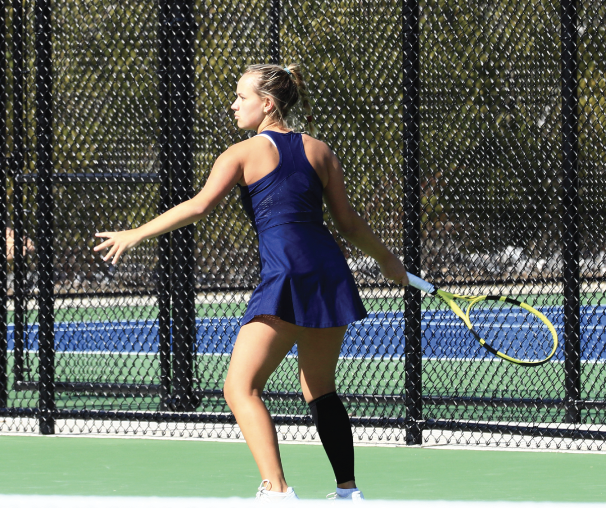 Eliza Muse winds up to hit a forehand.